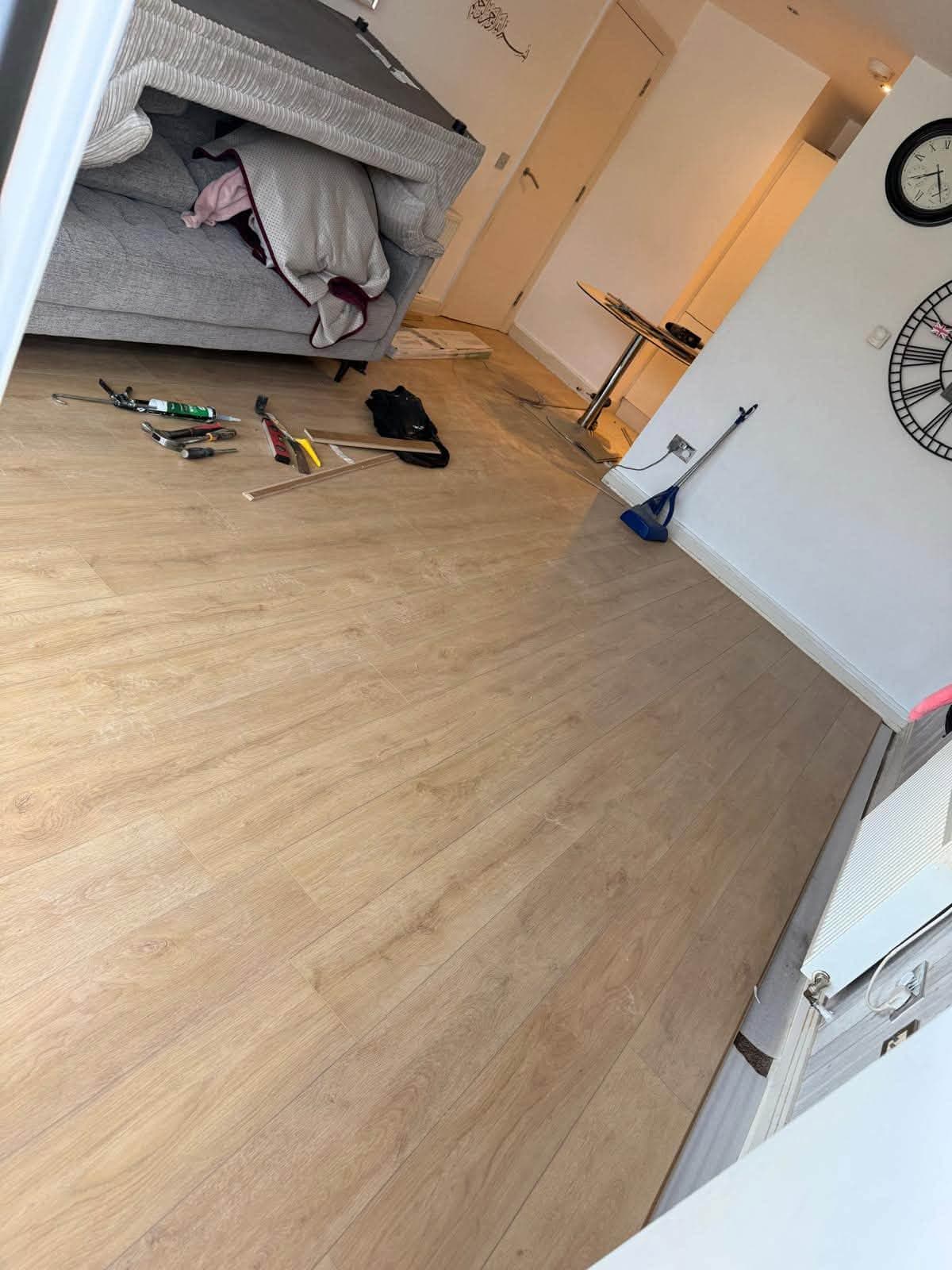 New wood-effect flooring being laid through a living room
