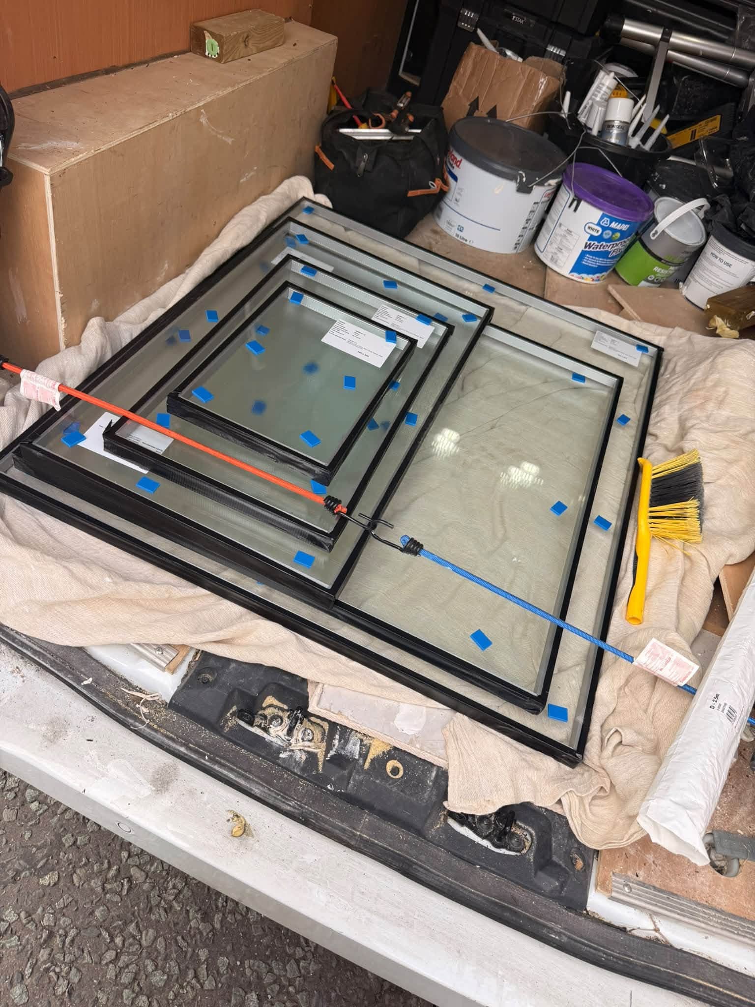 Multiple replacement glazed window units stacked carefully for installation