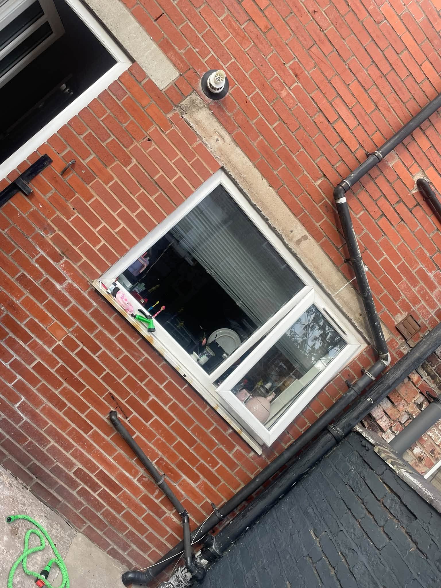 Exterior window on a brick property before new metal bars were fitted